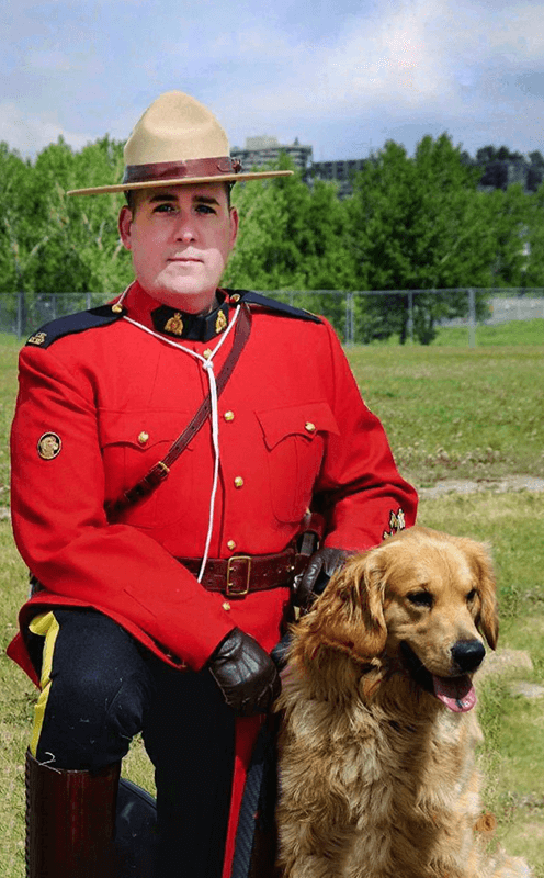 Portrait photo of an RCMP officer in the Red Surge with a K9 Police Service Dog to his side